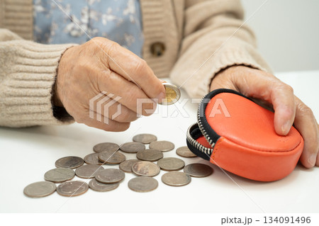 Asian senior or elderly old lady woman holding counting coin money in purse. Poverty, saving problem in retirement. Asian senior or elderly old lady woman holding counting coin money in purse. Poverty, saving problem in retirement. 134091496