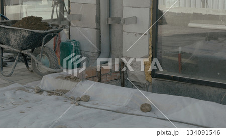 Construction workers operating machinery and mixing materials on the site 134091546