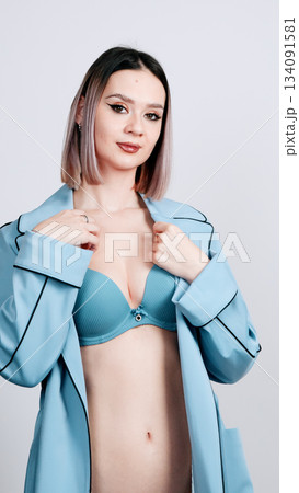 Female model posing in a stylish light blue trench coat robe 134091581