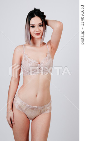 a woman posing in nude panties, covering her breasts with one arm. a woman posing in nude panties, covering her breasts with one arm. 134091653