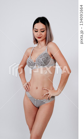 Full-length shot of a woman posing in a simple beige bra and panties set Full-length shot of a woman posing in a simple beige bra and panties set 134091664