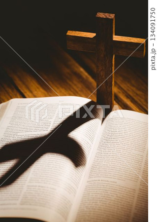 Wooden cross with shadow on bible Wooden cross with shadow on bible 134091750