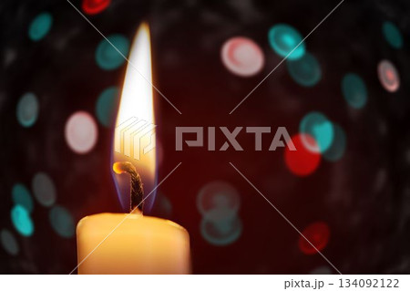 Candle burning against festive background Candle burning against festive background 134092122