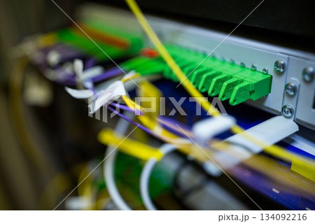 Fiber optic patch panel is displaying green ports and colored cables on rack in flat design Fiber optic patch panel is displaying green ports and colored cables on rack in flat design 134092216