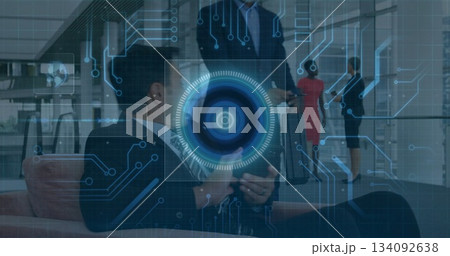 Collaborating team manipulating holographic interface in modern corporate lobby, with tablet 134092638