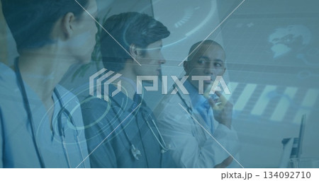 Three doctors wearing white lab coats and stethoscopes studying data on digital screen in hospital Three doctors wearing white lab coats and stethoscopes studying data on digital screen in hospital 134092710