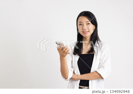 スマートフォンを持って微笑む女性 スマートフォンを持って微笑む女性 134092948