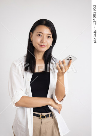 スマートフォンを持って微笑む女性 134092952