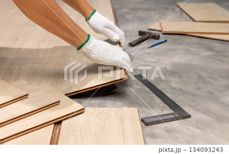 Worker Installing Interlocking laminate floor, home renovation. Worker Installing Interlocking laminate floor, home renovation. 134093243
