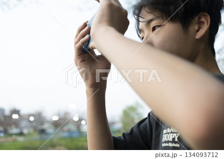 スマホを構える男の子 134093712