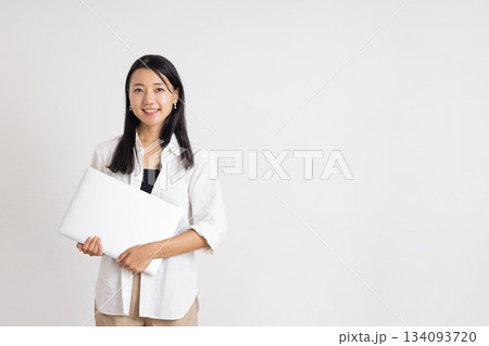 ノートパソコンを持って微笑む女性 134093720