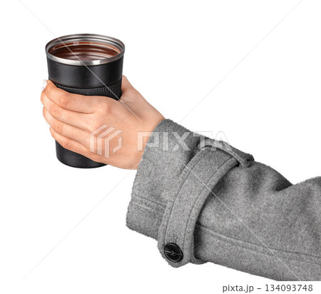 Hot chocolate. Hand holding reusable travel cup with hot drink isolated on white background with copy space 134093748