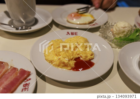 喫茶店モーニングのスクランブルエッグと目玉焼きが並ぶ卵料理プレート 喫茶店モーニングのスクランブルエッグと目玉焼きが並ぶ卵料理プレート 134093971