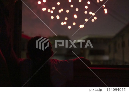 家の中から花火を楽しむ子ども 134094055