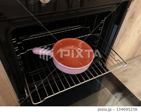 Empty ceramic pan with one handle, pot baking dish for roasting food in oven on rack. Traditional national cookware, Europe. Healthy eating at home. Mock up for design. Empty ceramic pan with one handle, pot baking dish for roasting food in oven on rack. Traditional national cookware, Europe. Healthy eating at home. Mock up for design. 134095256