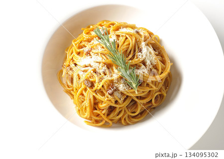 粉チーズとローズマリーの乗ったスパゲッティミートソースを白背景で撮影 134095302