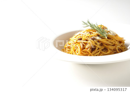粉チーズとローズマリーの乗ったスパゲッティミートソースを白背景で撮影 134095317