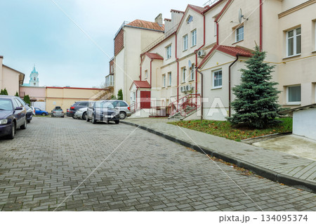 Residential Parking Area with Cars, Paved Road and Pastel Buildings Residential Parking Area with Cars, Paved Road and Pastel Buildings 134095374