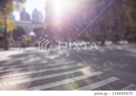 Zebra-striped crosswalk is stretching across sunlit city street with lens flare in flat design 134095870
