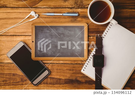 Small wooden chalkboard is being shown on flat design desk with phone, pen, coffee, smartwatch Small wooden chalkboard is being shown on flat design desk with phone, pen, coffee, smartwatch 134096112