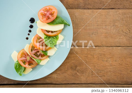Fresh salad in plate on wooden table 134096312