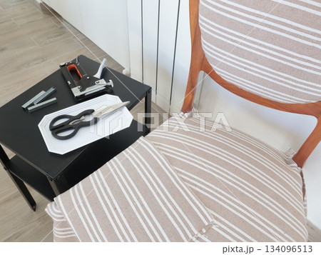 Restoration of old vintage furniture at home. Furniture stapler, staples and other tools. Handicrafts and hobbies.  134096513