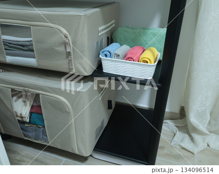Storage of bed linen and household items on shelf in room. Modern new fabric boxes, organiser, container with zip fastener.  134096514