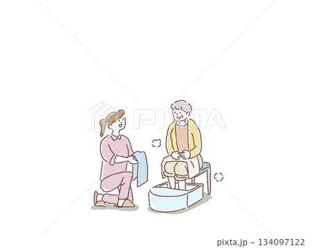 足湯をする高齢女性とタオルを差し出す、看護師、介護士、ヘルパーの女性 134097122