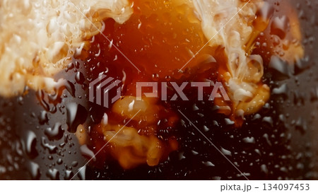 Macro Shot of Pouring Milk into Ice Coffee, Close-up Macro Shot of Pouring Milk into Ice Coffee, Close-up 134097453