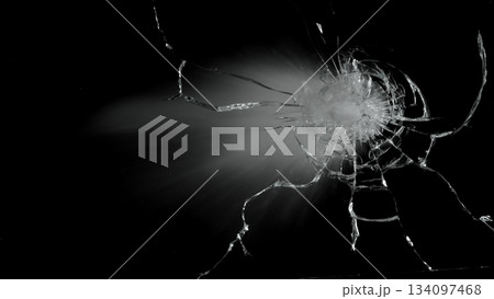 Freeze Motion Shot of Glass Shattered by a Bullet from a Pistol on Black Background 134097468