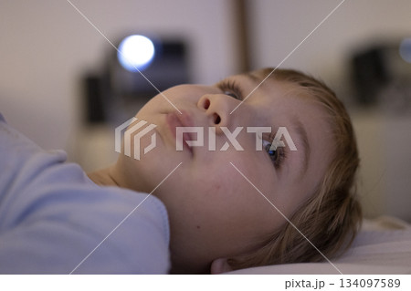 Young child looking up while relaxing Young child looking up while relaxing 134097589