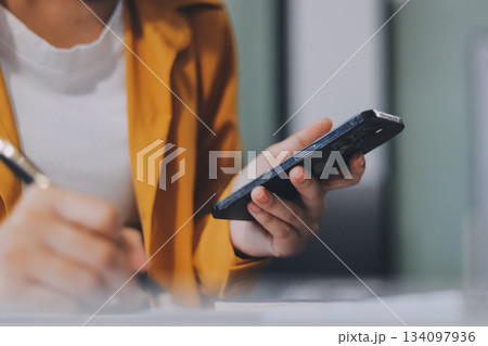 Business woman using calculator for do math finance on wooden desk in office and business working background, tax, accounting, statistics and analytic research concept. 134097936