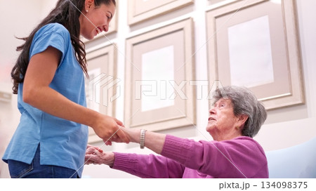 Young woman helping senior citizen in a nursing home Young woman helping senior citizen in a nursing home 134098375