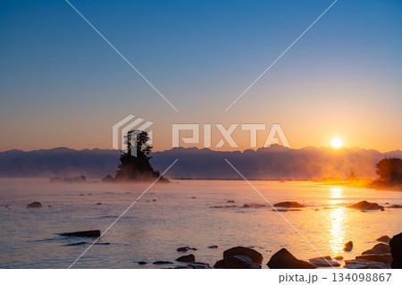 【冬の風物詩】雨晴海岸の気嵐と後立山連峰から登る朝日【富山県】 134098867