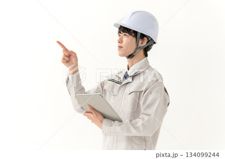 タブレットを持つ作業着の若い男性 タブレットを持つ作業着の若い男性 134099244