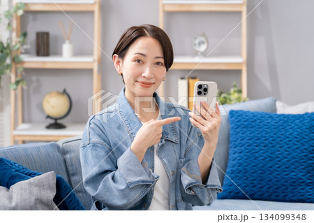 スマホを持つ女性　指差し 134099348