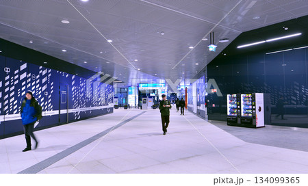Warsaw, Poland. 28 November 2025. Commuters going through the underground passage hall at Warszawa Zachodnia train station. Ceiling mounted large artificial illumination. 134099365