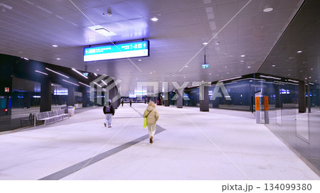 Warsaw, Poland. 28 November 2025. Commuters going through the underground passage hall at Warszawa Zachodnia train station. Ceiling mounted large artificial illumination. 134099380