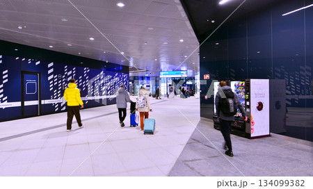 Warsaw, Poland. 28 November 2025. Commuters going through the underground passage hall at Warszawa Zachodnia train station. Ceiling mounted large artificial illumination. 134099382