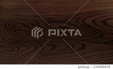 うねる木目がきれいに浮き出た焦茶色のテーブルの背景画像 134099470