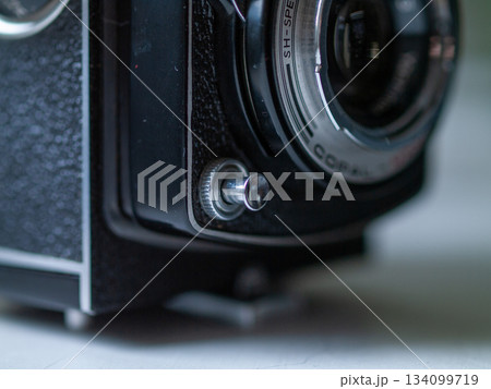 Vintage lens with textured body, Detailed shot of retro camera with metal controls and leather surface 134099719