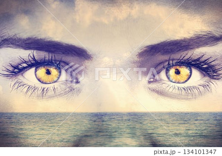 Surreal digital design showing golden-yellow eyes merging with calm ocean horizon and cloudy sky Surreal digital design showing golden-yellow eyes merging with calm ocean horizon and cloudy sky 134101347