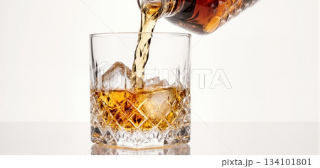 Smooth whiskey pour into an ice-filled glass with a clean white background 134101801