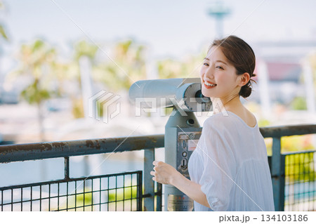 望遠鏡で観光地の景色を楽しむ若い女性 134103186