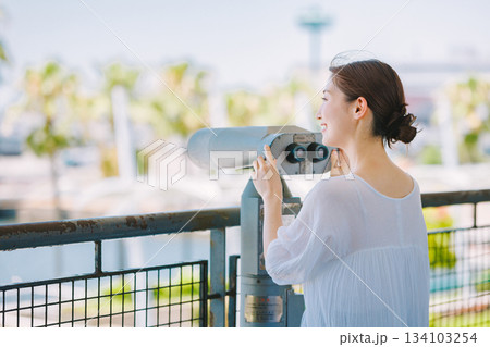 望遠鏡で観光地の景色を楽しむ若い女性 134103254