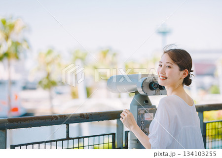 望遠鏡で観光地の景色を楽しむ若い女性 望遠鏡で観光地の景色を楽しむ若い女性 134103255
