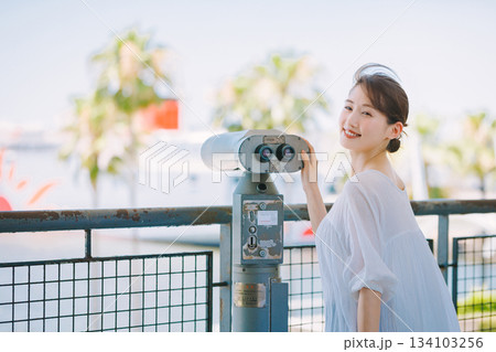 望遠鏡で観光地の景色を楽しむ若い女性 134103256