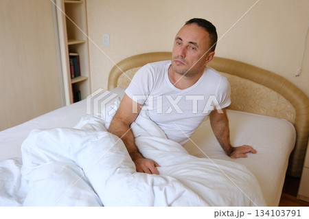 Man waking bed man wearing sleepwear waking up in bed and stretching his arms in bedroom at home. male person doing morning exercises for health indoors Man waking bed man wearing sleepwear waking up in bed and stretching his arms in bedroom at home. male person doing morning exercises for health indoors 134103791
