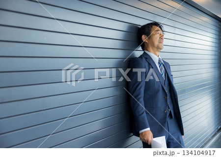 店舗物件の前で考えるビジネスマン　 134104917