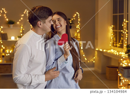 Young Couple Embracing and Holding a Red Heart on Valentine Day 134104984
